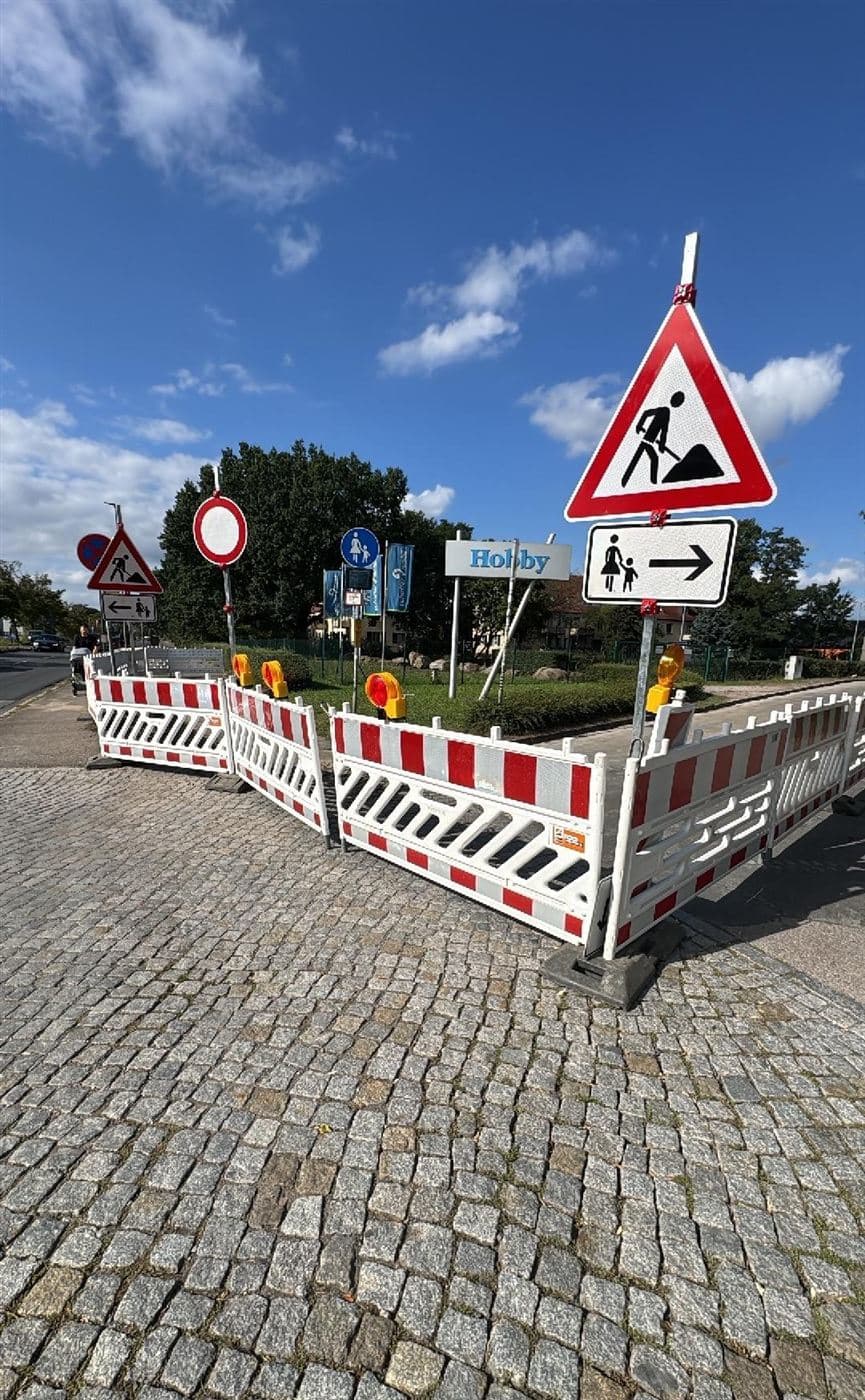 Abgesicherte Glasfaser-Baustelle in Dresden-Pieschen: Absperrschranken mit Warnleuchte, Verkehrszeichen Arbeitsstelle und Verbot für Fahrzeuge an einem Gehweg
